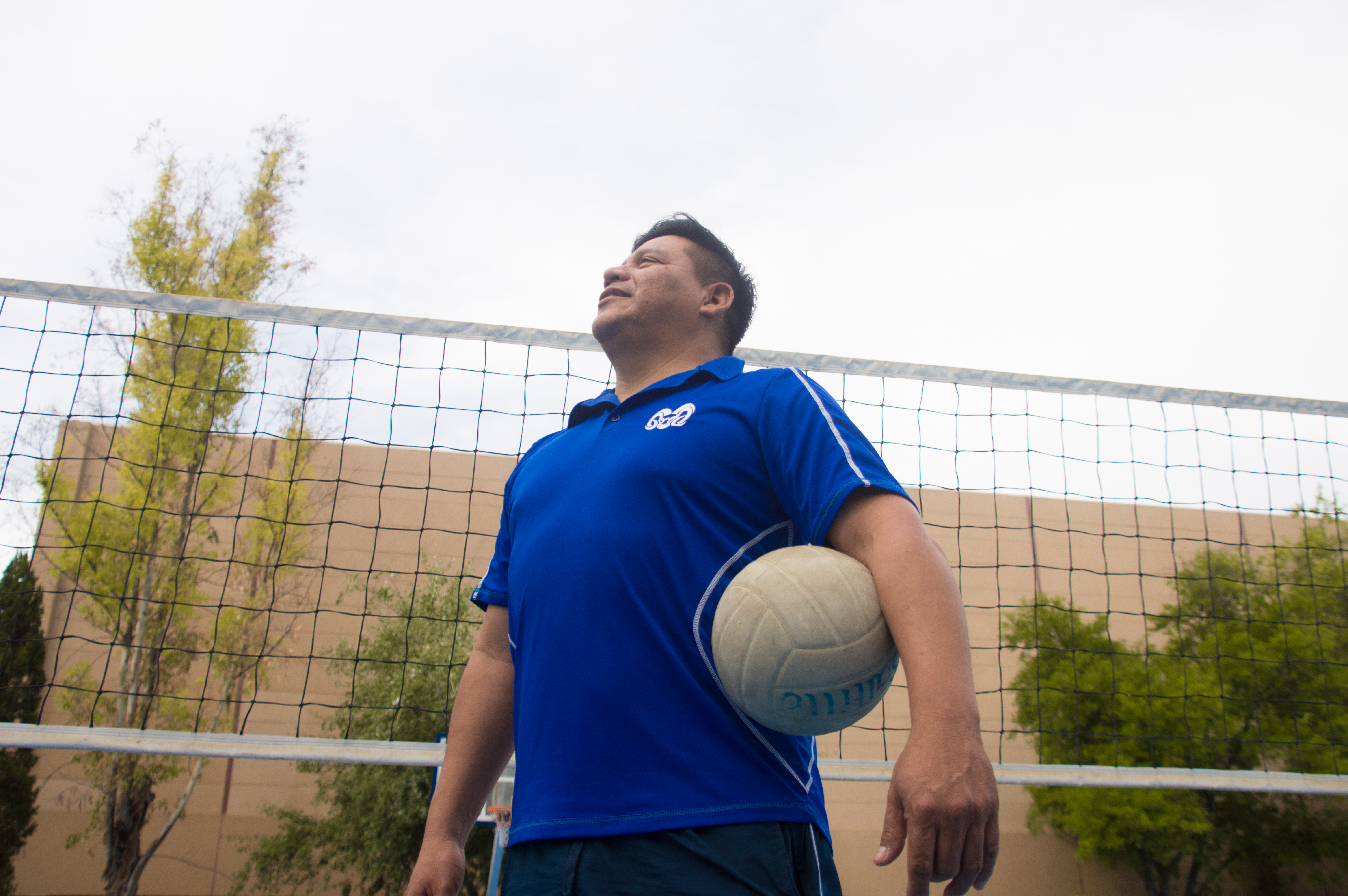 Hombre mirando hacia el horizonte con un balón de voleibol