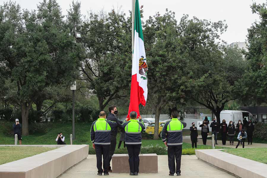 Personal de seguridad del campus entregan la bandera para ser izada