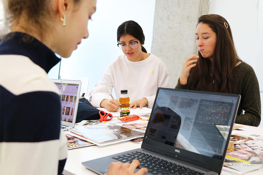 Alumnas  de estudios creativos diseñando e investigando en sus computadoras 