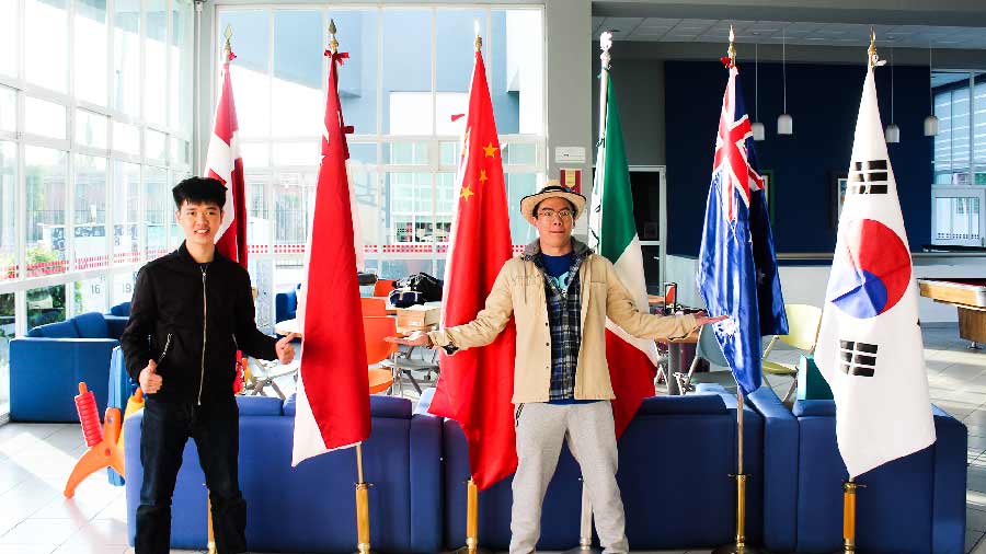 Students posing in front of flags