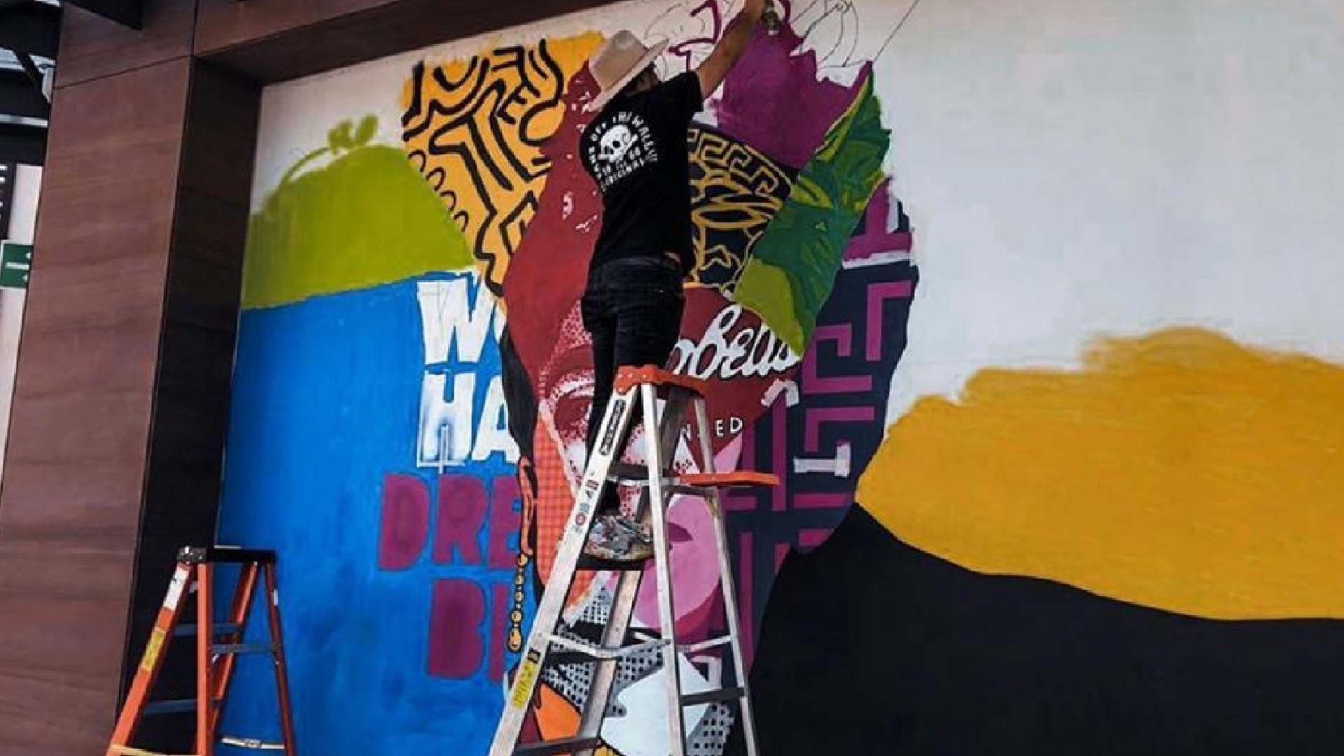 Joca Torres pintando un mural en Town Square Metepec