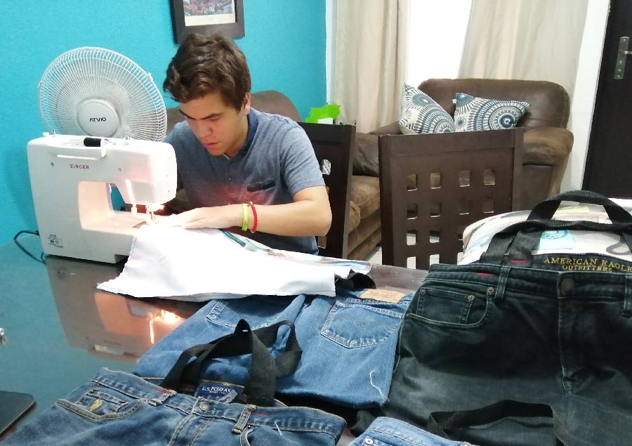 José Mario Flores usando su maquina de coser para hacer bolsas ecológicas 