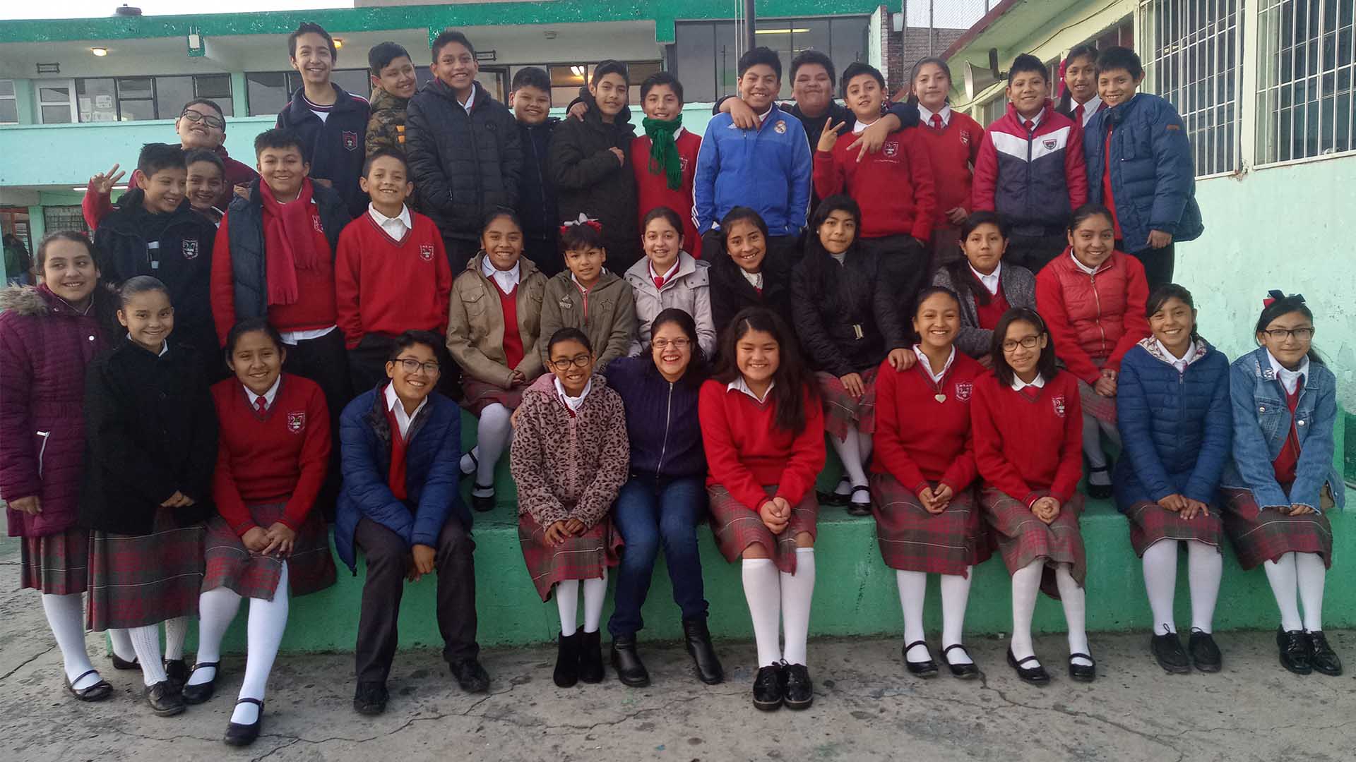 Nancy Rodríguez con alumnos de la escuela secundaria impactada
