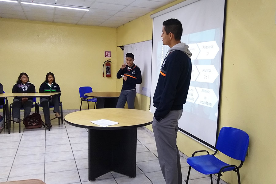 Sebastián frente a un grupo de alumnos, presentando una conferencia de PERMA