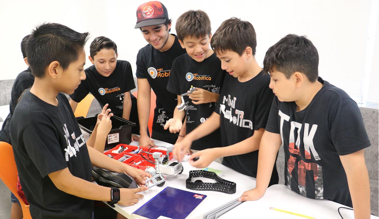 Menores trabajan con un robot en programa Mini Robótica
