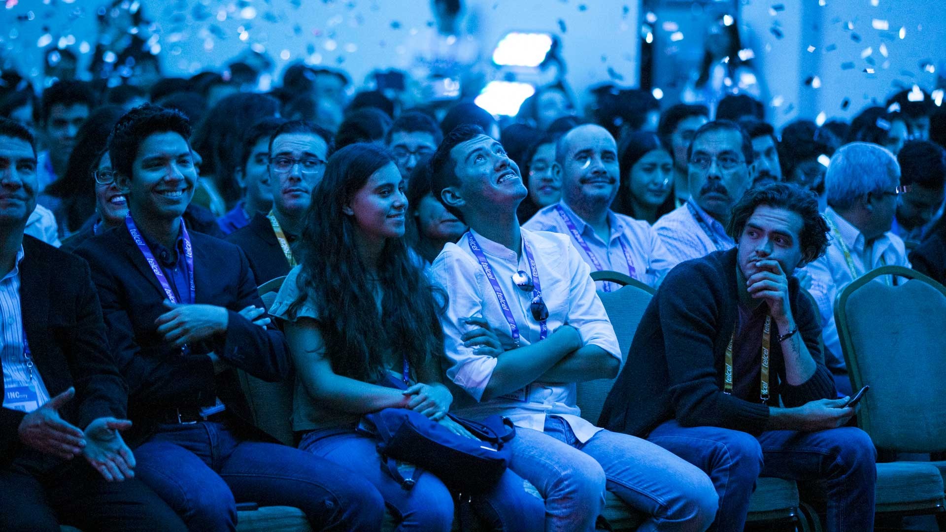 Los asistentes reaccionan ante lluvia de papeles en el auditorio. INCmty 2019