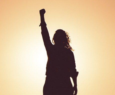 Sombra de mujer alzando la mano contra la violencia de género