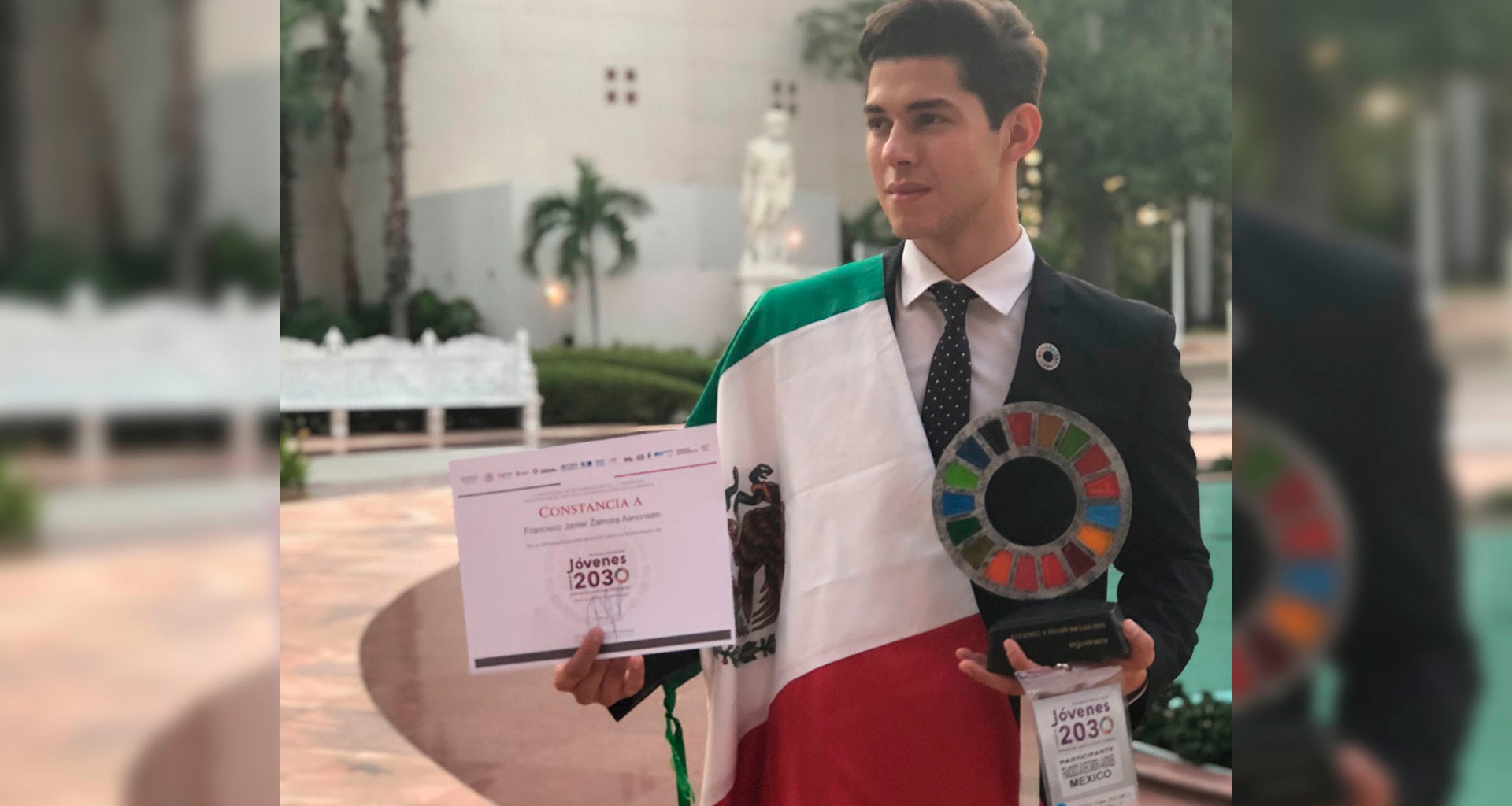 Paco Zamora, foto de ganador, con su premio, reconocimiento y bandera de México.