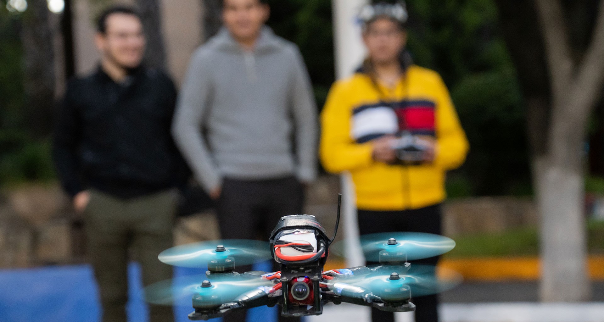 Tres de los cinco jóvenes pilotando un dron