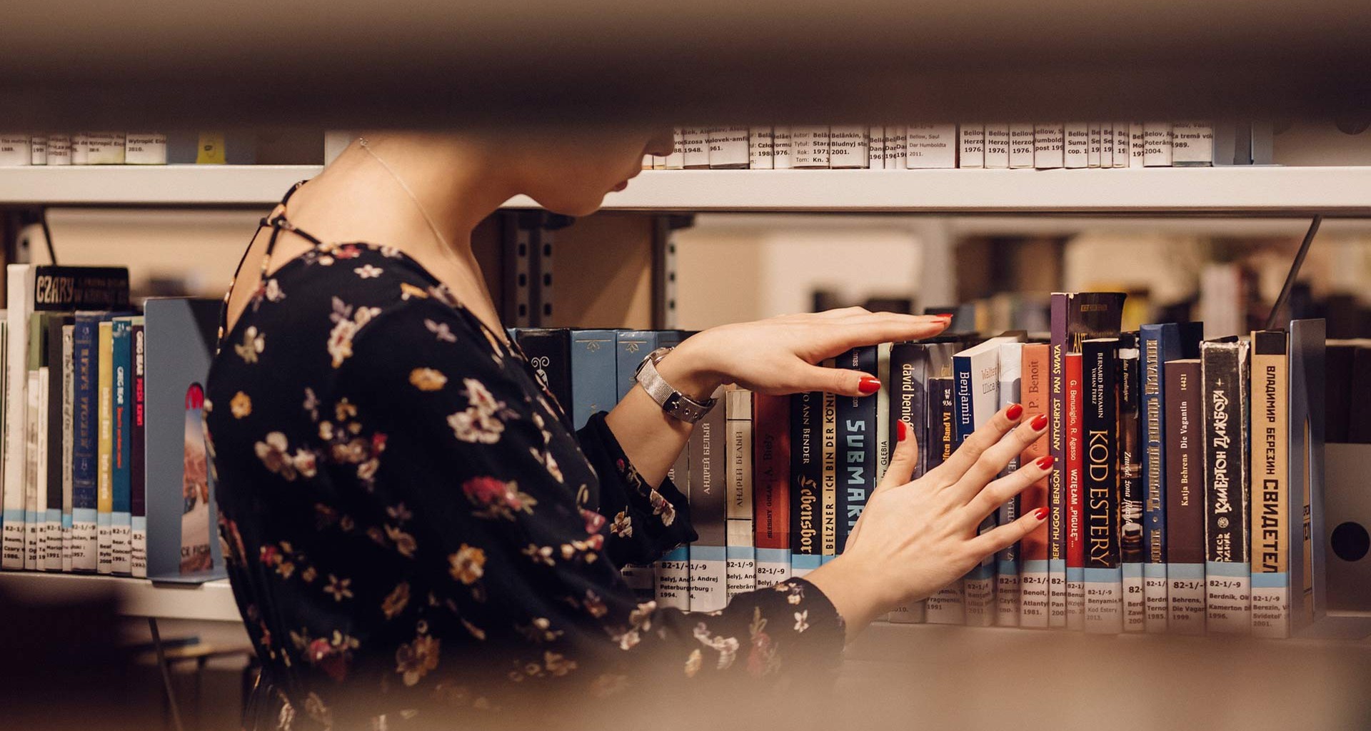 mujer en biblioteca buscando libros