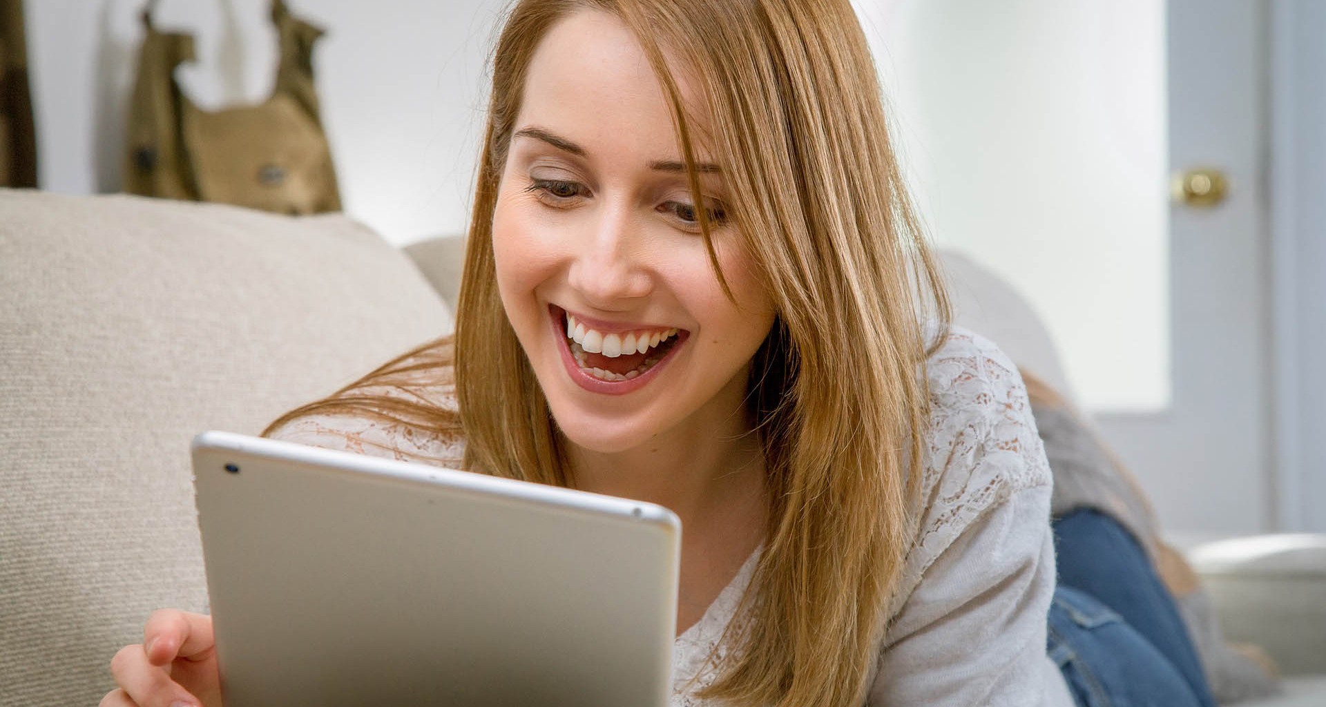mujer mirando su tablet mientras sonríe