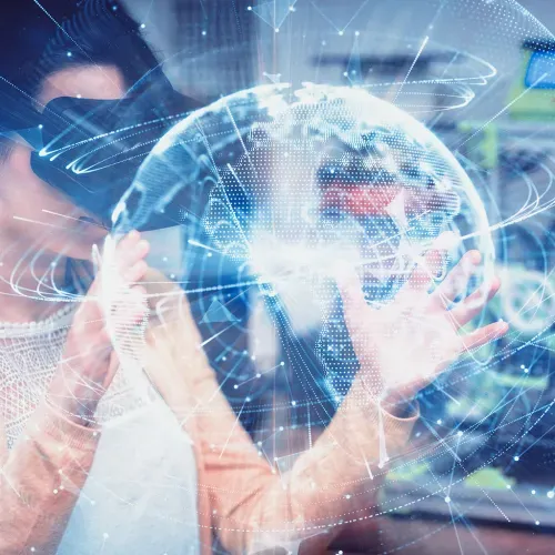 Person using virtual reality goggles interacting with a digital model of planet Earth, surrounded by graphs and technological connections.