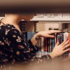 mujer en biblioteca buscando libros