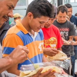 Migrantes con alimentos en las manos