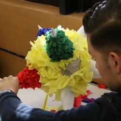 Alumnos decorando piñata en la actividad Viva México