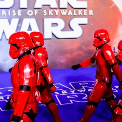 Stormtroopers desfilando con poster de starwars al fondo