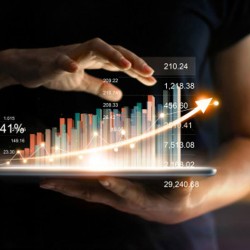 Empresario sosteniendo tableta mostrando holograma virtual creciente con estadísticas 
