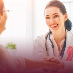 Doctora portando listón rosa y paciente, temática prevención cáncer de mama