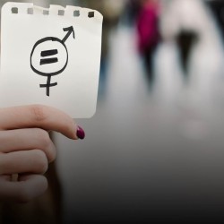 Mujer sosteniendo una hoja con signo de igualdad de género