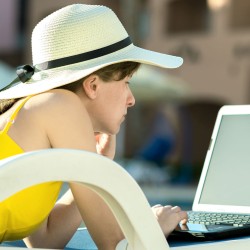 mujer trabajando en laptop con ropa de verano
